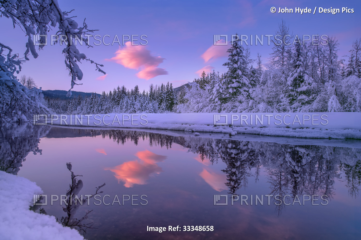 Winter landscape at the last light of sunset with a pink cloud floating in the ...