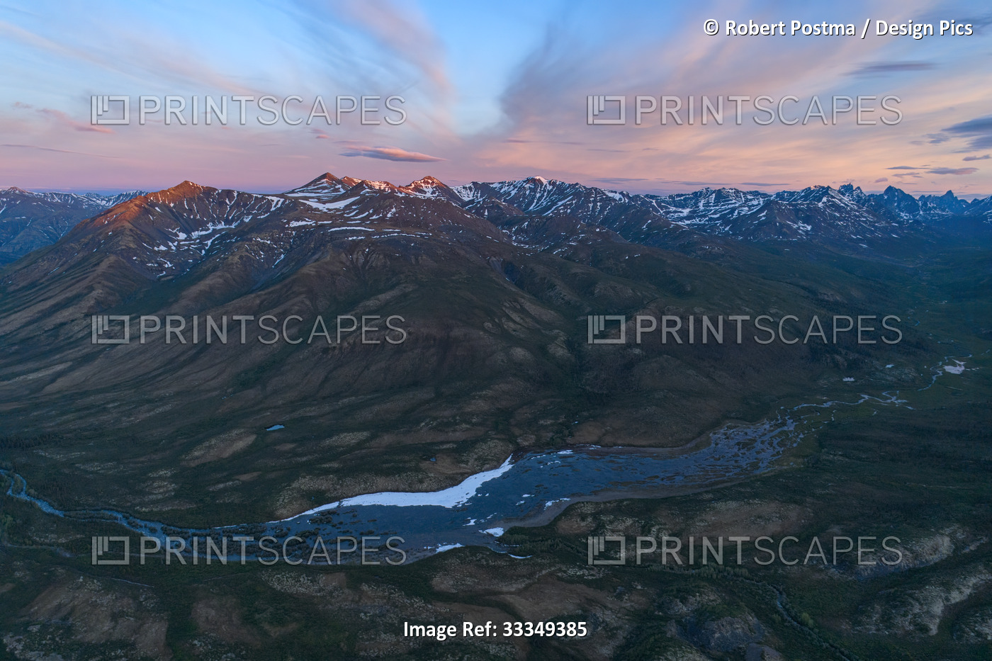 Aerial view of the dramatic mountain ranges and a river running through the ...