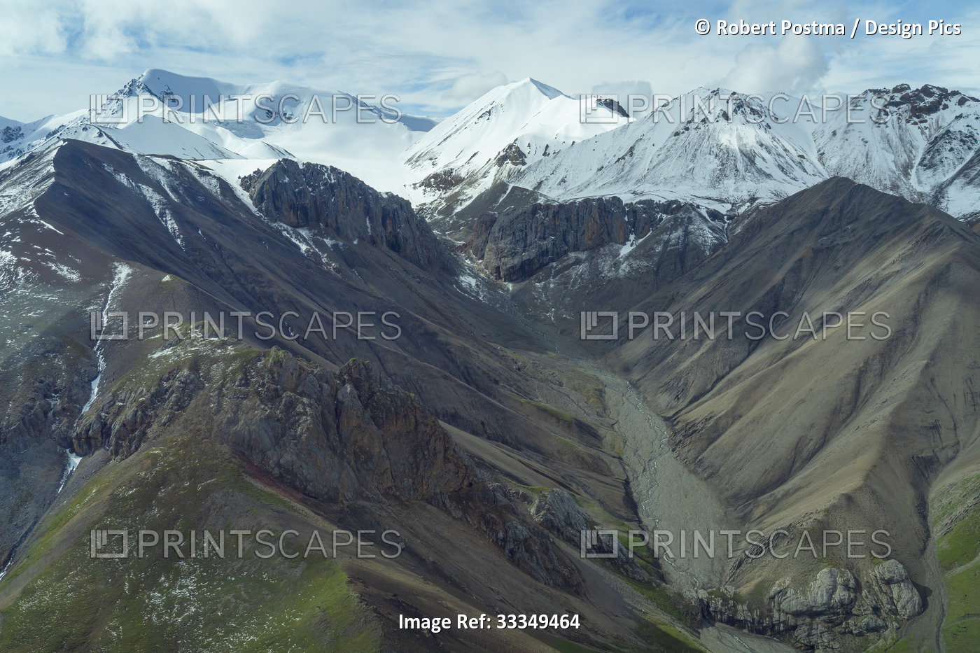 Aerial view of slopes of ancient sedimentary and volcanic rock with snowcapped ...