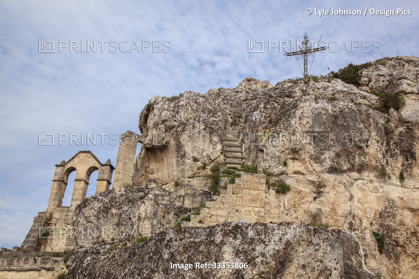 Christian cross and ruins on the rocky mountaintop; Matera, Basilicata, Italy