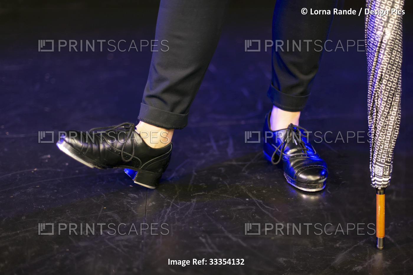 Close-up of tap shoes on a tap dancer, posing on a black floor; Langley, ...