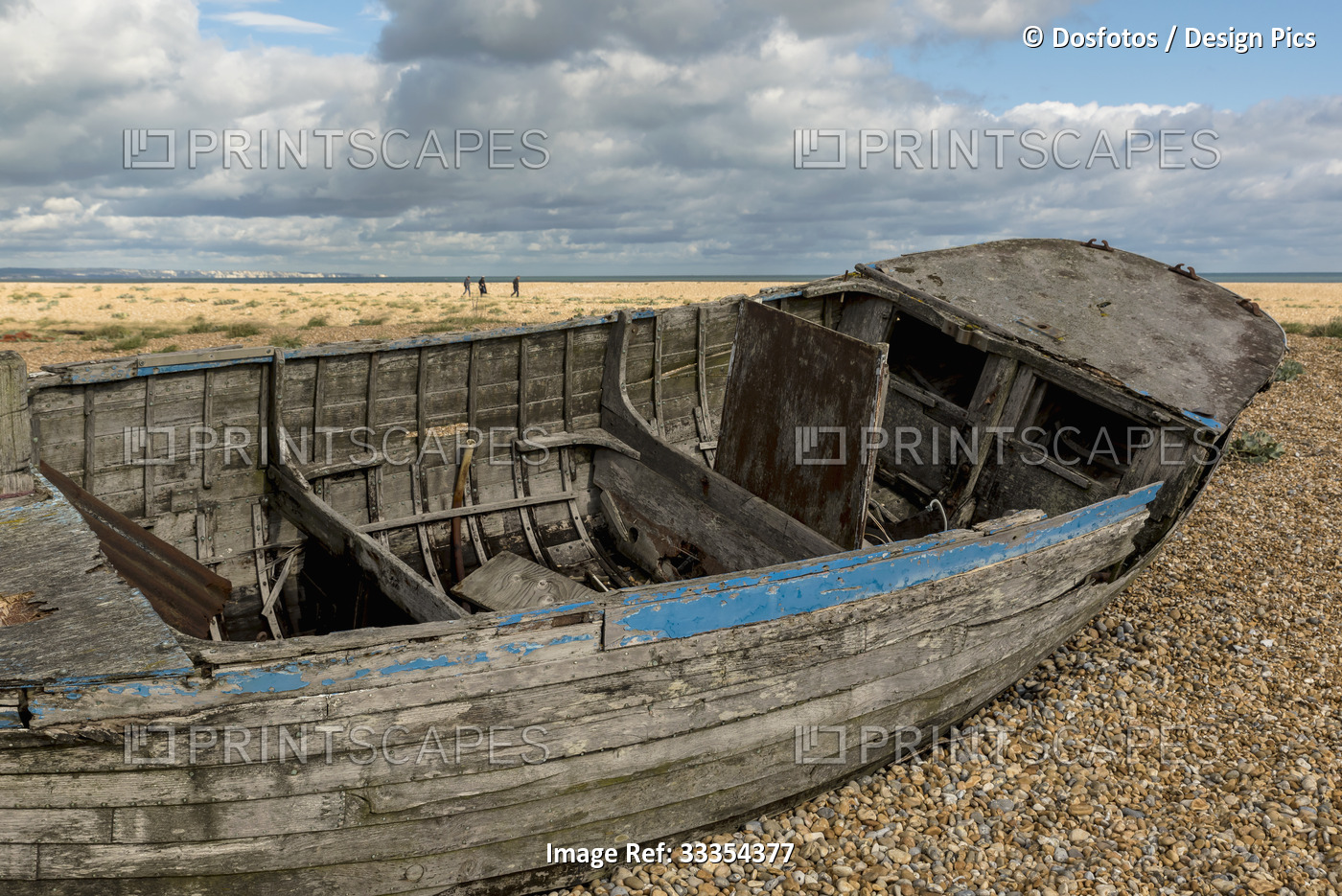 Close-up of an old,abandoned wooden boat aground on the shingle beach along the ...