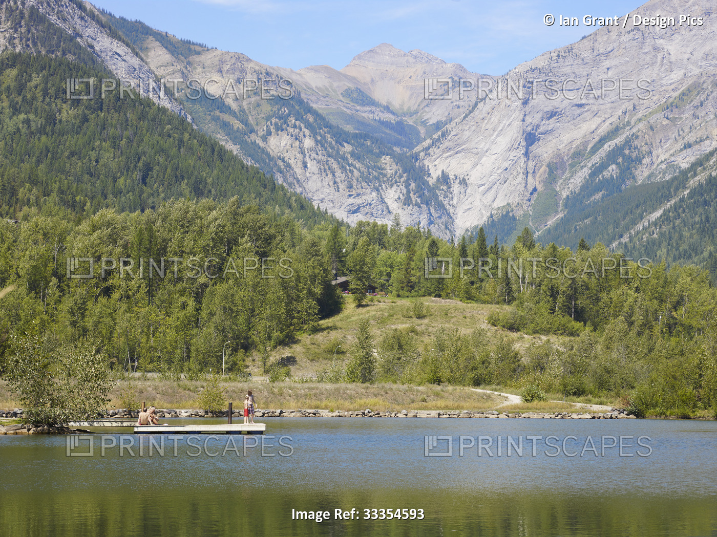People on a dock on Maiden Lake in the Rocky Mountains; Fernie, British ...