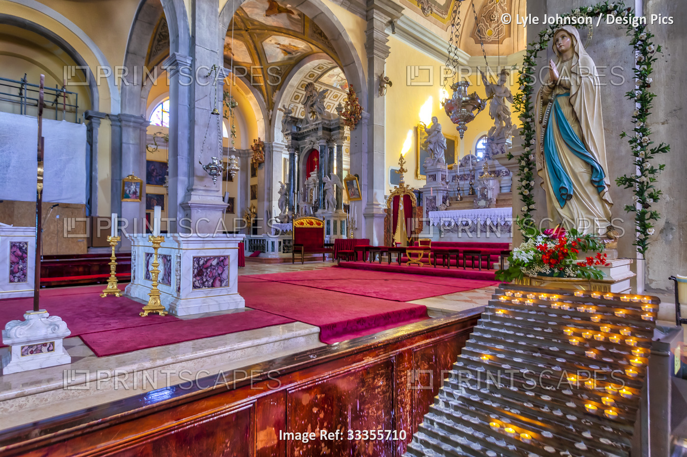 Interior of the Church of St Euphemia, showing a religious statue and candles ...