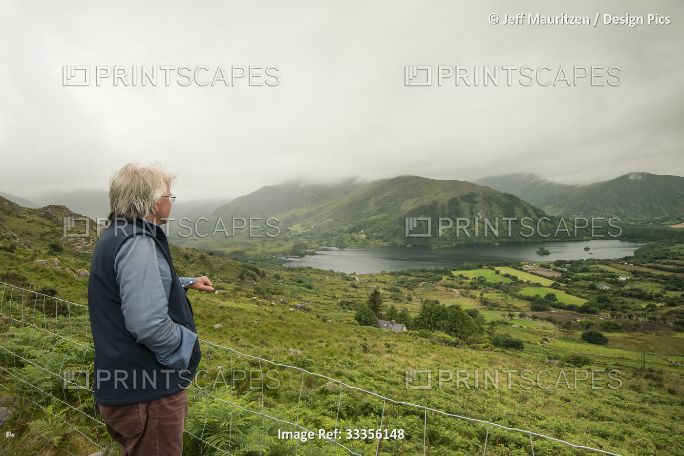 A man gazes out over Glanmore Lake and the atmospheric landscape of the Beara ...