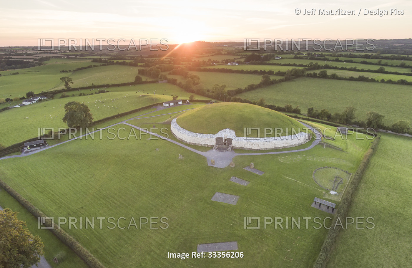 Aerial view of a sunset and surrounding farmland at the ancient passage tomb ...
