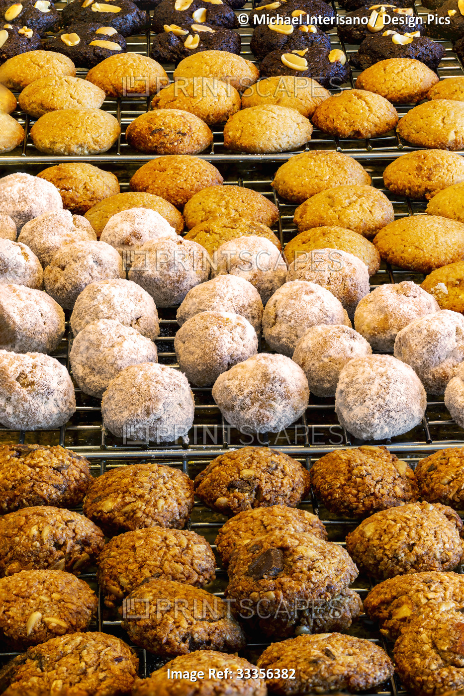 Close up of several different small round cookies all in rows on a cooling ...