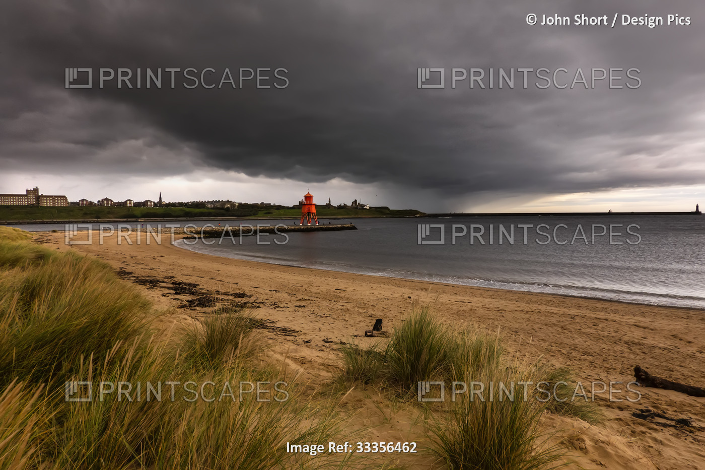 Herd Groyne Lighthouse with storm clouds overhead, and Tyne South Pier ...