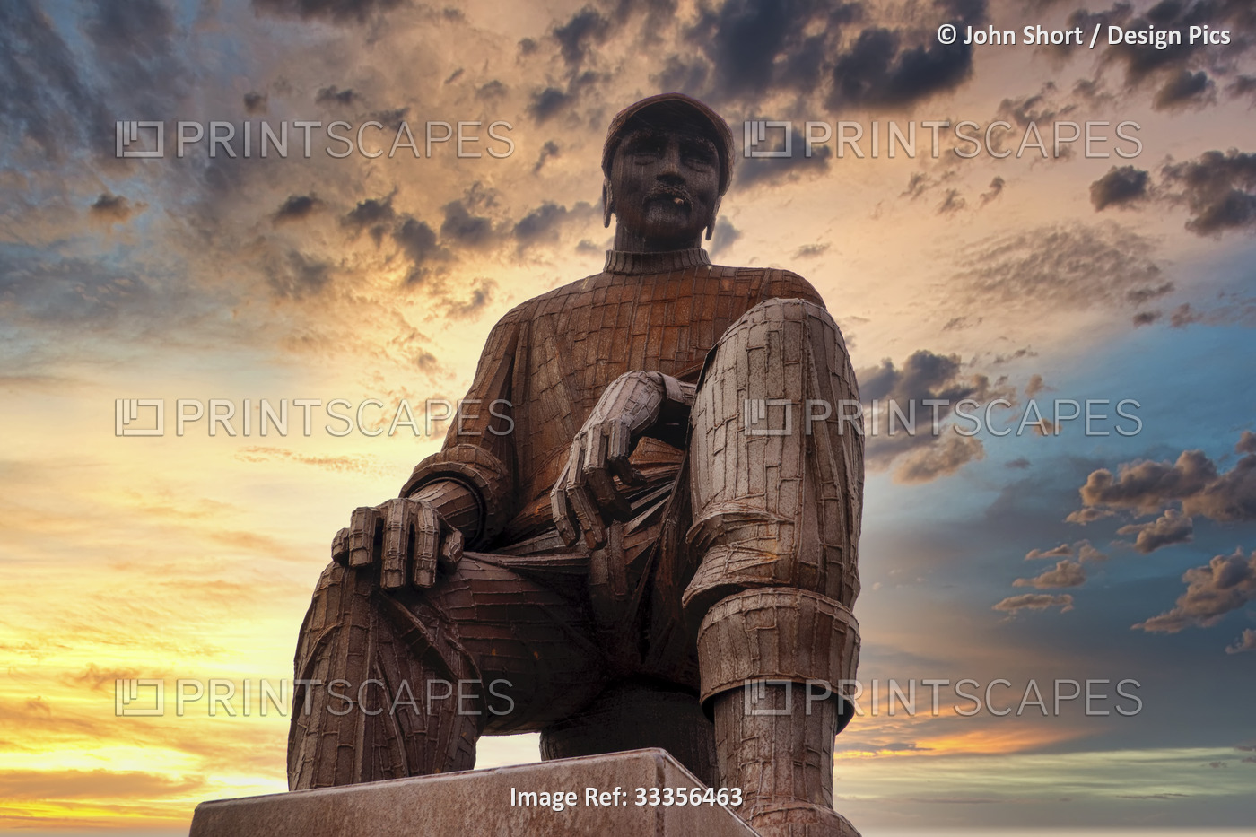 Fiddler's Green Fishermen's Memorial with colourful glowing clouds at sunset; ...
