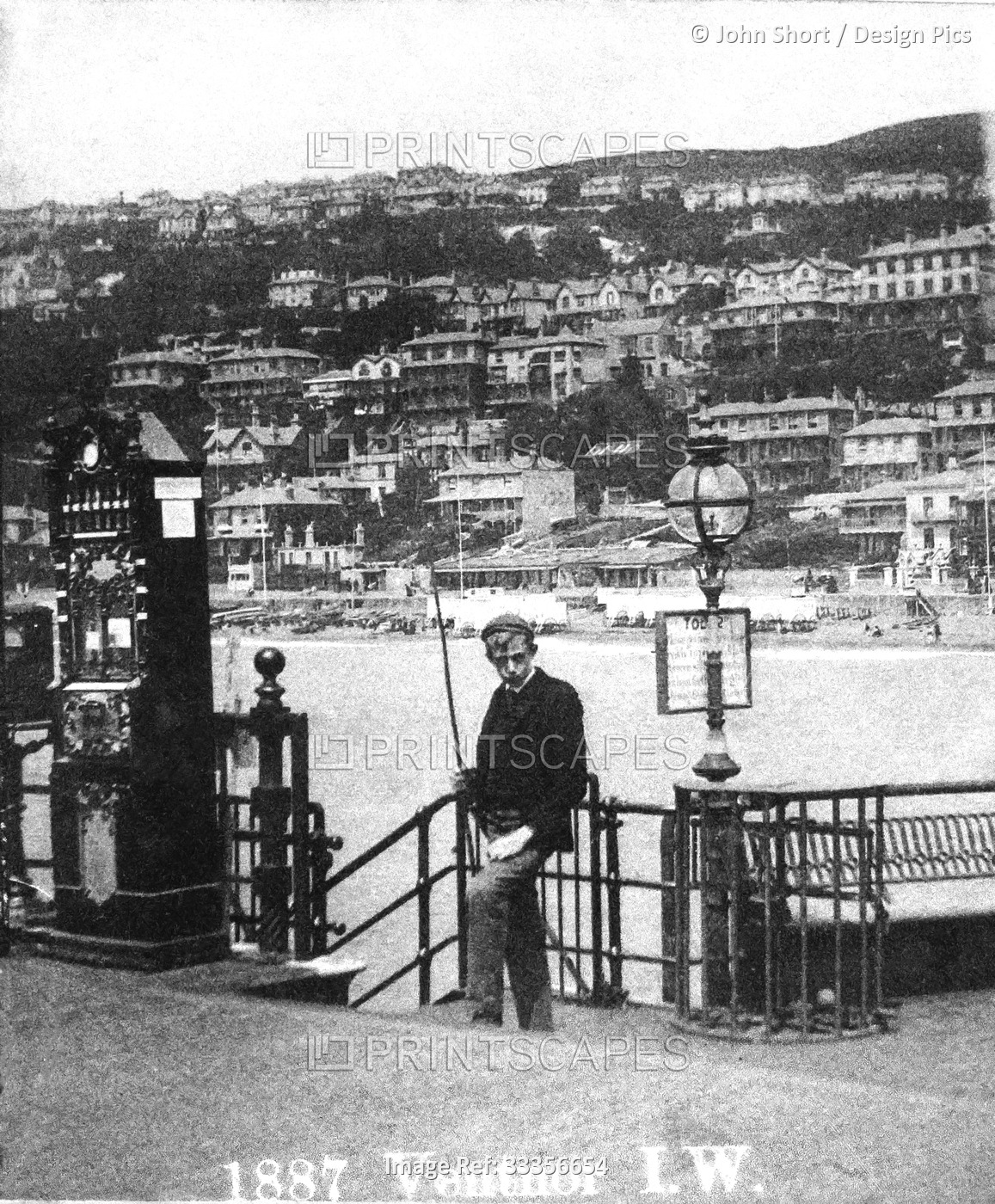Young man on pier at Ventnor, Isle of Wight, standing beside a name tag ...