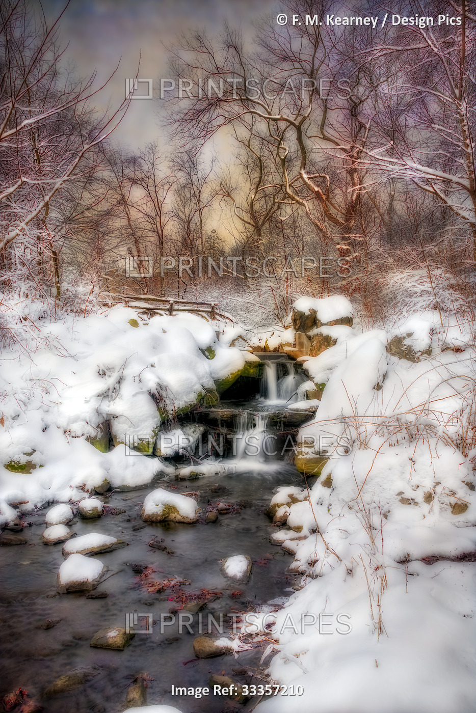 Waterfall under snow-covered rustic bridge in Central Park; New York City, New ...