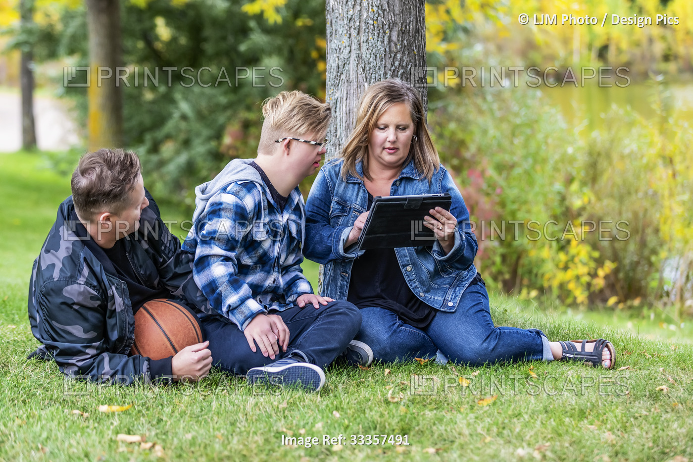 A young man with Down Syndrome sitting with his family and playing games on a ...