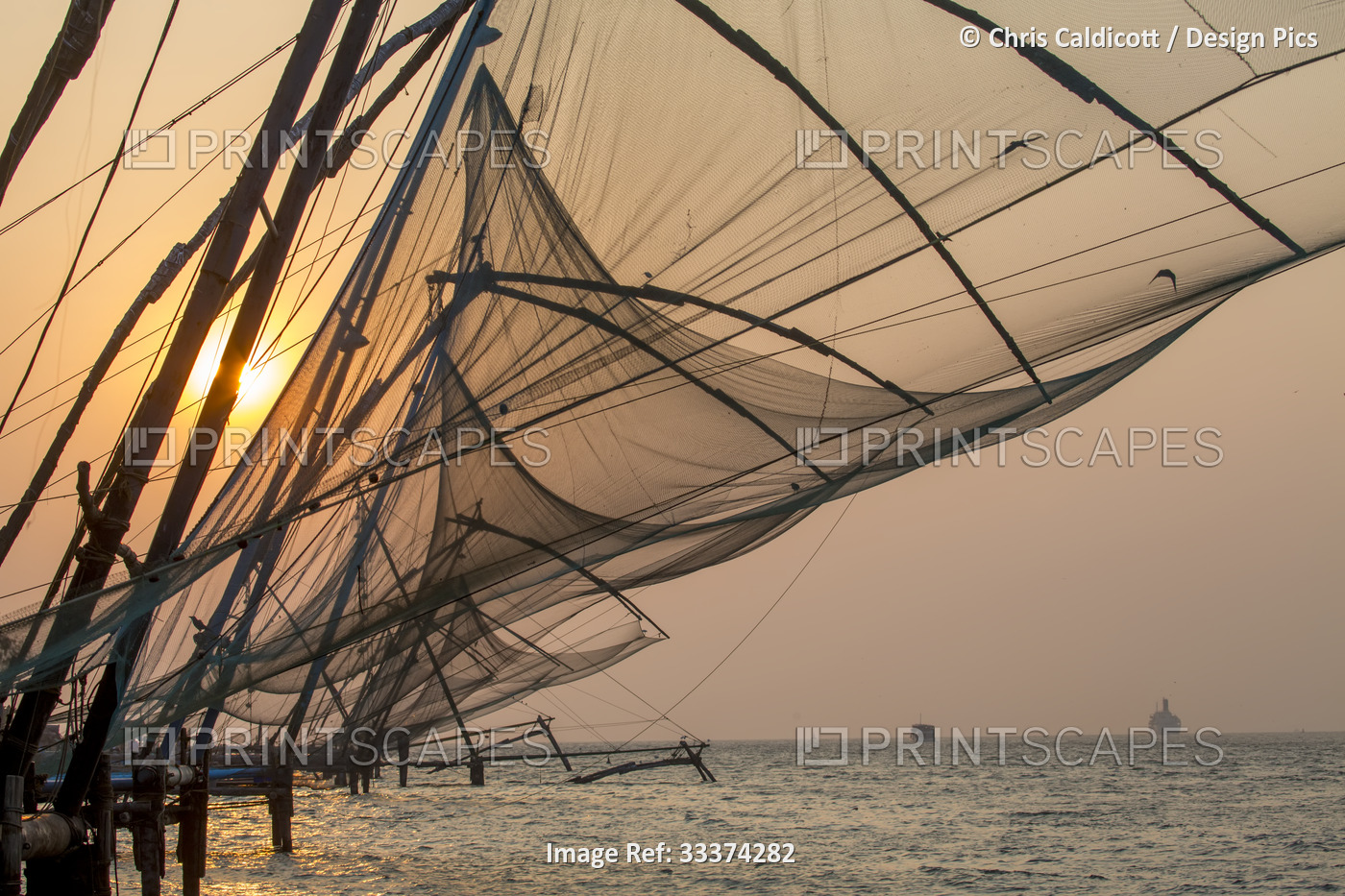 Traditional, 'Chinese' fishing nets at sunset in the mouth of the harbor; ...