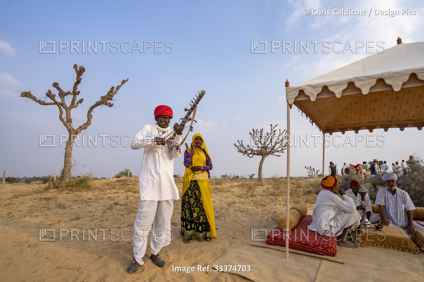 Rajput man playing ravanahatha and woman singer performing at festival with ...