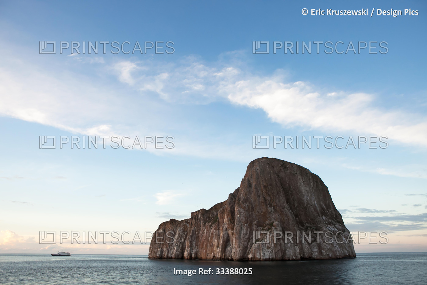 A expedition vessel passes near a large rock formation near the Galapagos ...