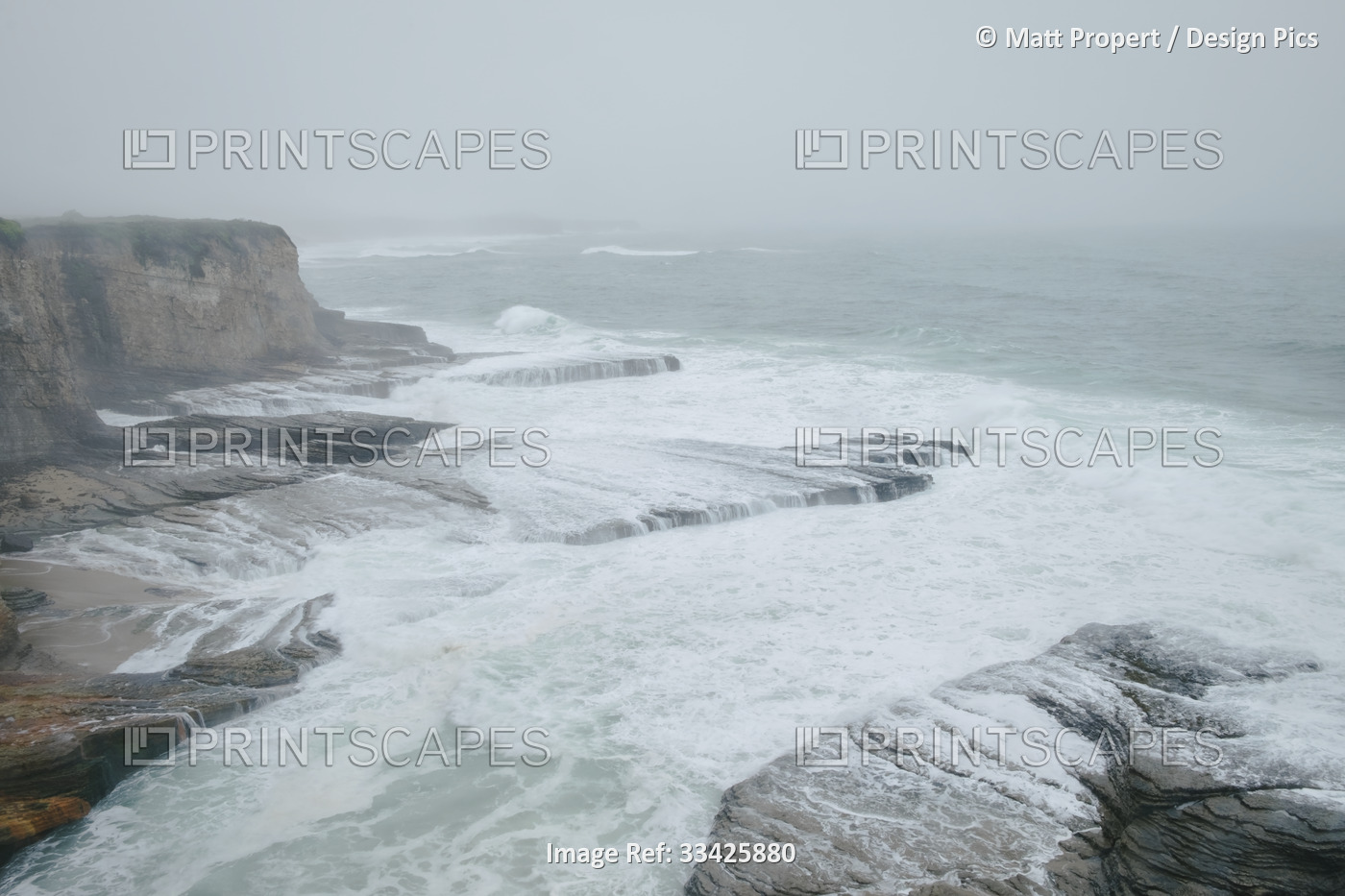 Large storm surf with waves crashing against the rock shelf along the rocky ...