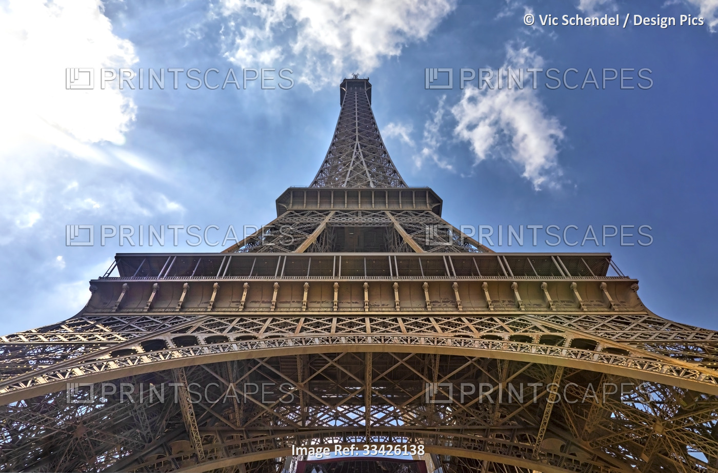 Low angle view of the Eiffel Tower against a cloudy blue sky; Paris, Ile de ...