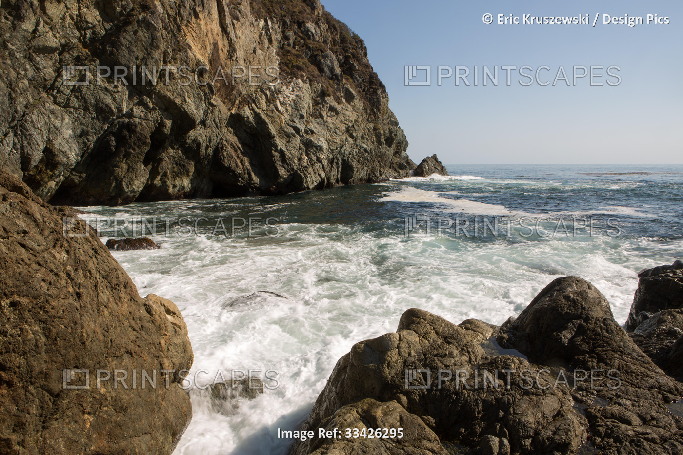 Water rushes between rocks in a cove on the Big Sur coast.; Big Sur, California