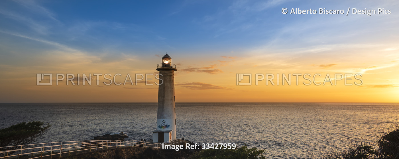 Lighthouse at Pointe du Vieux Fort overlooking the Caribbean Sea at sunset, ...