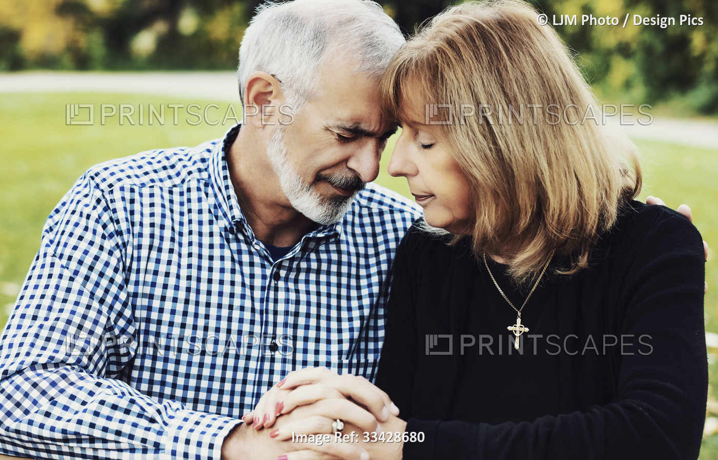 A mature couple sharing devotional time together by studying the Bible and ...