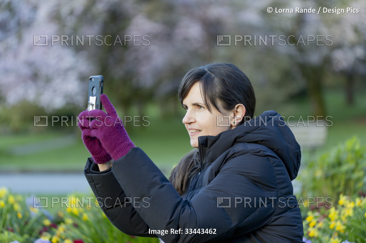 Middle aged woman taking a picture of her view with a smartphone while sitting ...