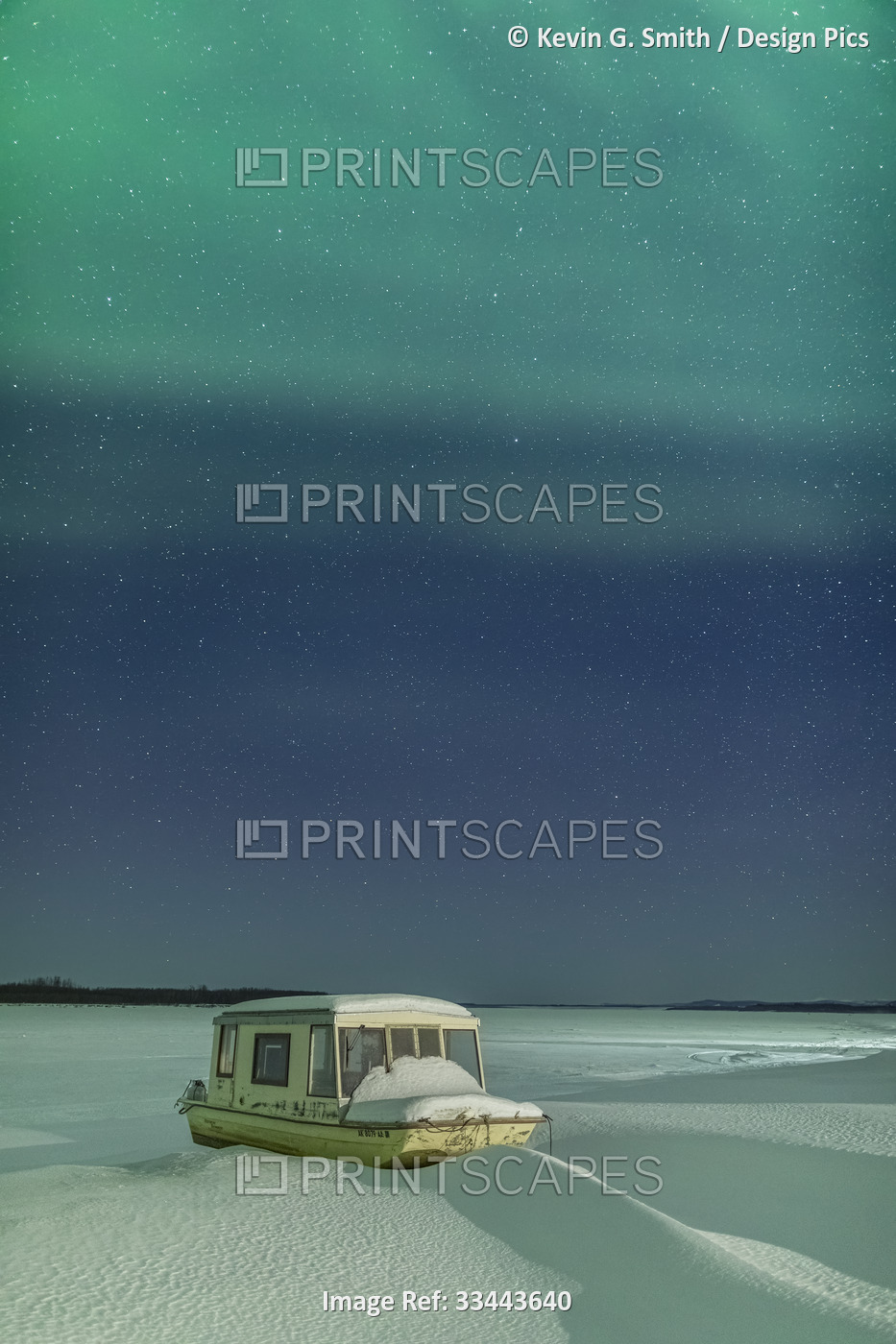 Northern Lights in the sky above a fishing boat pulled up on the shore of the ...