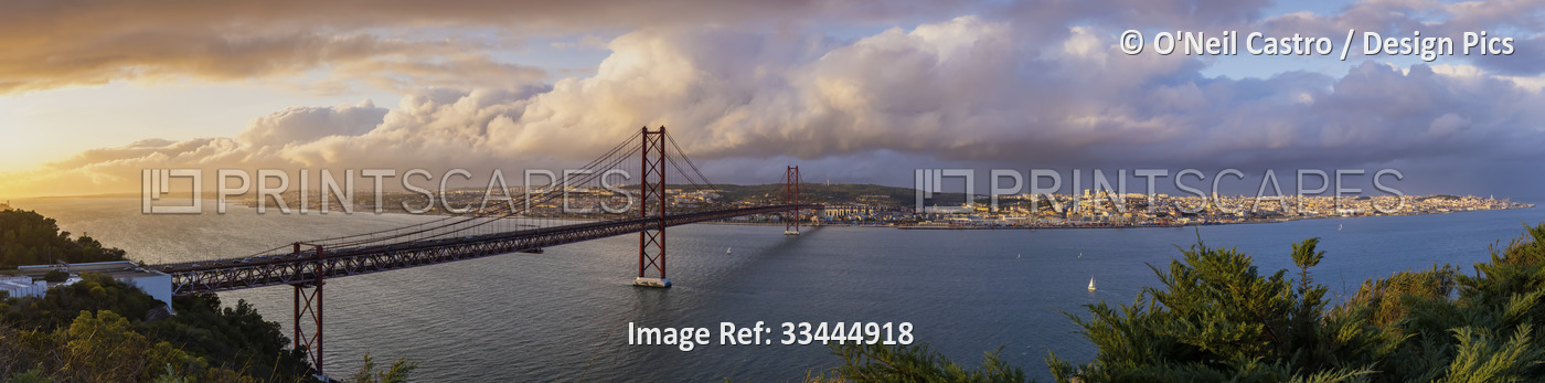 Panoramic view of 25 de Abril Bridge at sunset and cityscape of Lisbon; Lisbon, ...