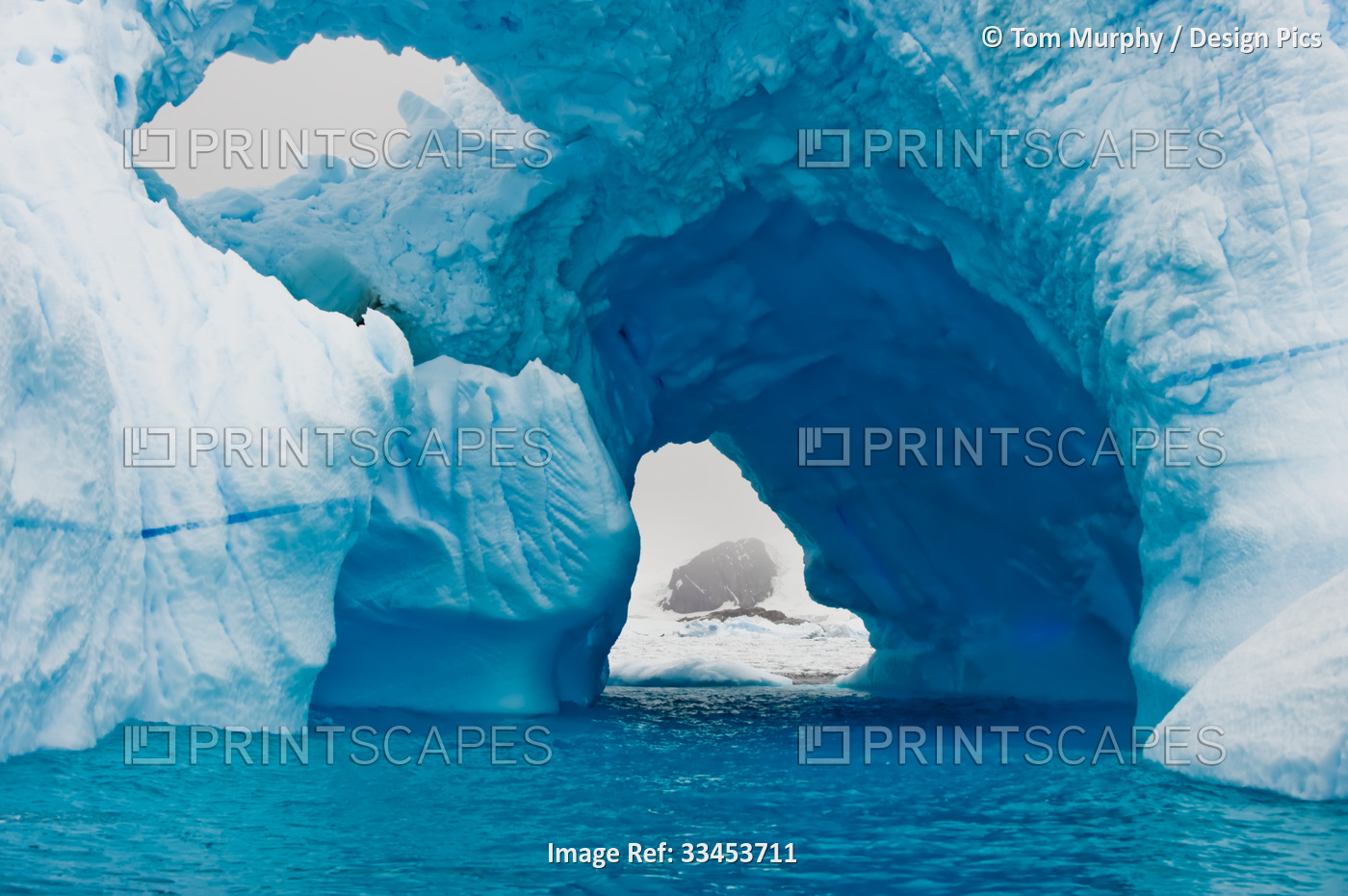 Dramatic blue ice tunnel in an iceberg in Cierva Cove of the Southern Ocean; ...