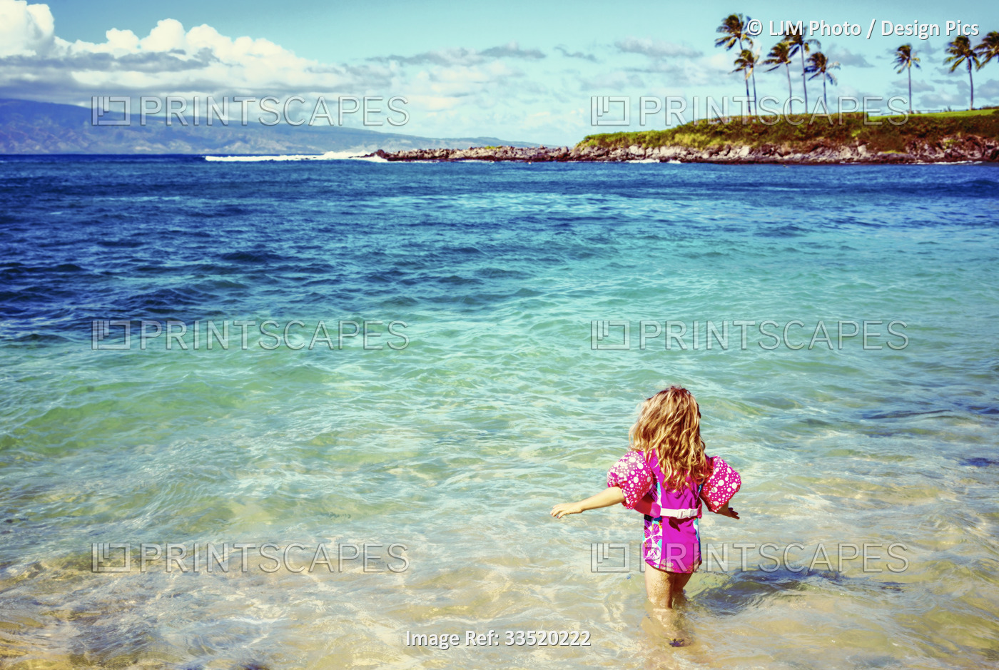 A young girl walks wades into the ocean water on Kapalua Beach at Kapalua Bay ...