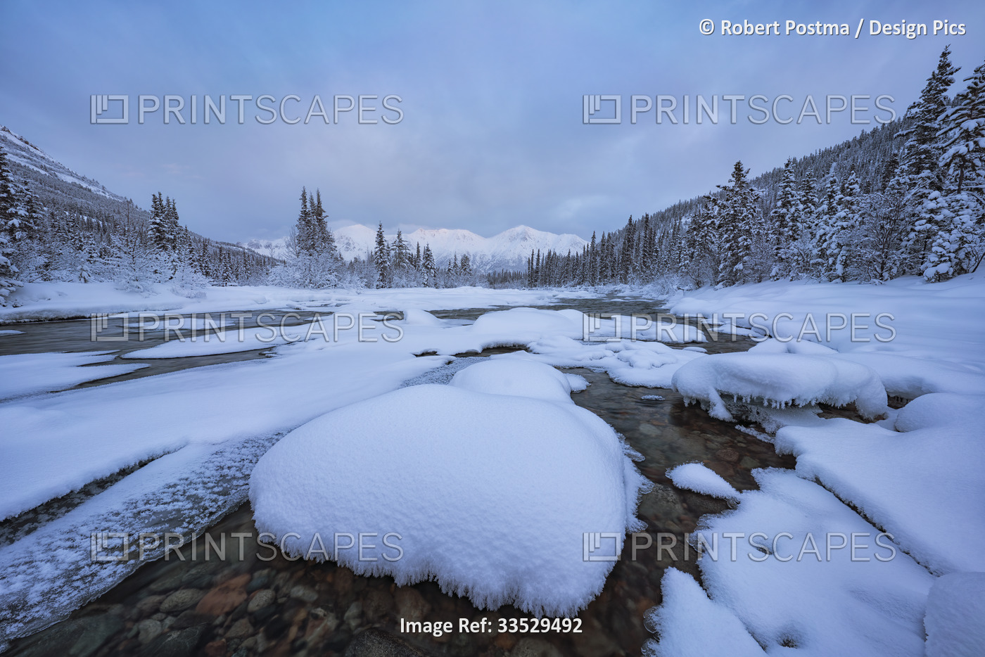 Snow covered rocks on Wheaton River with the mountains in the distance in ...