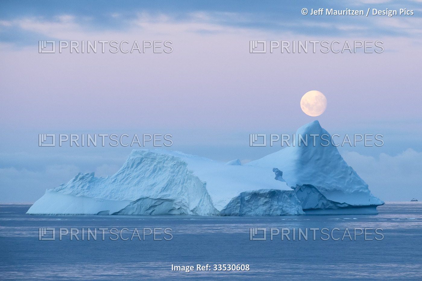 Full moon sets over an iceberg in the Gerlache Strait off the coast of the ...