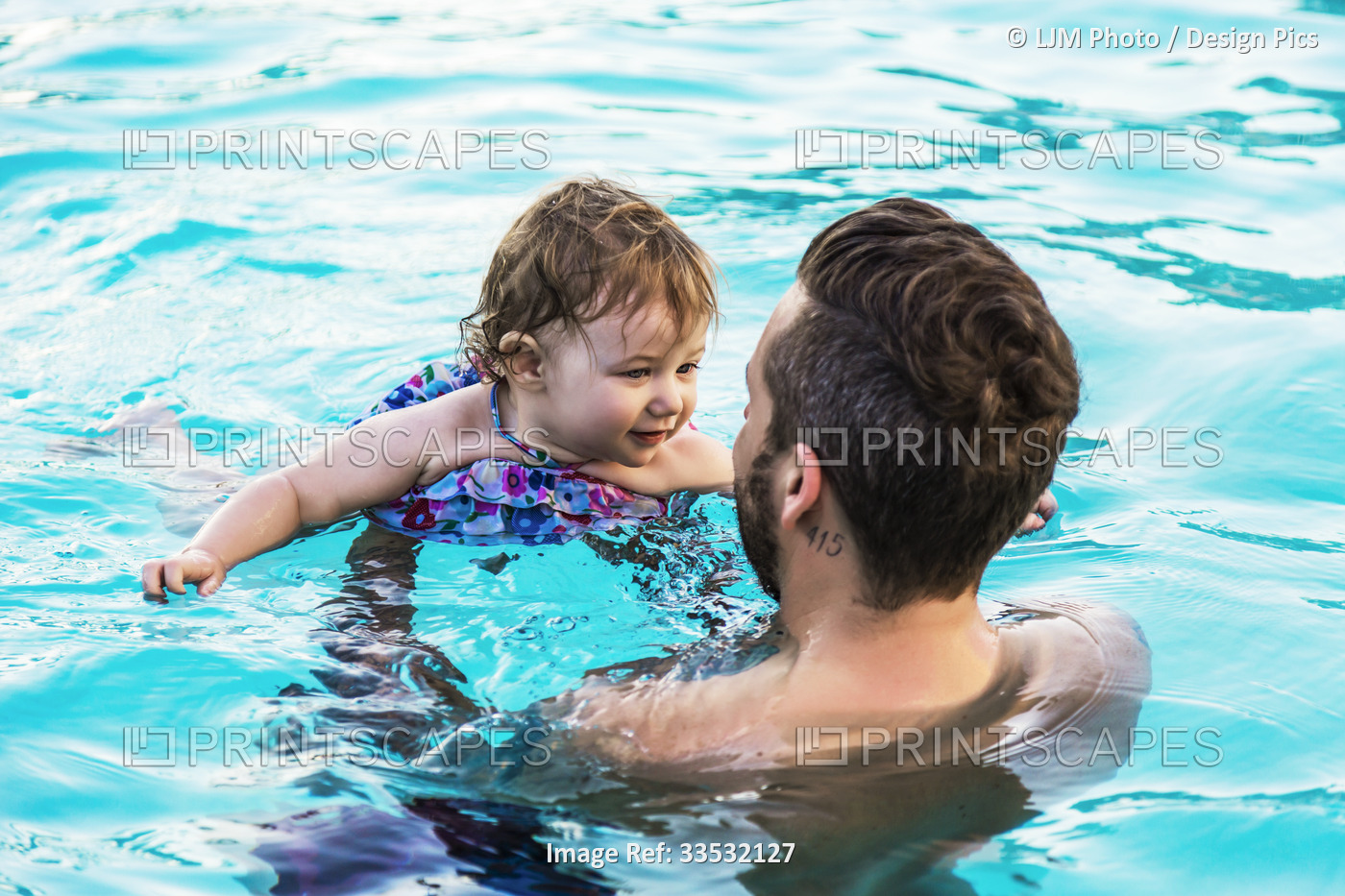 A father swims with his young daughter in the pool at a resort in Ka'anapali; ...