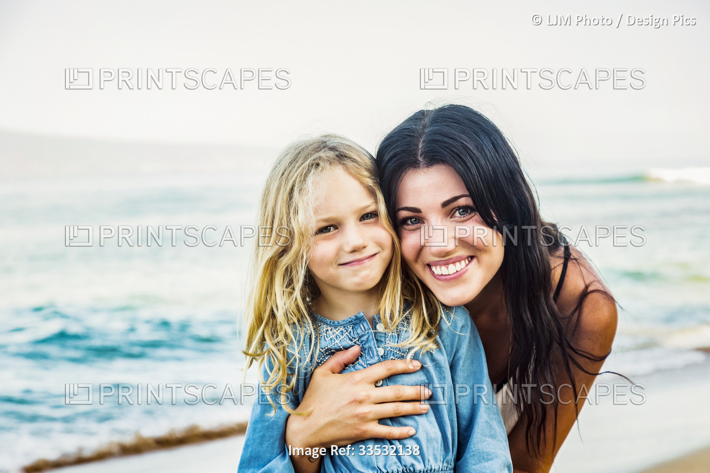 Portrait of a mother and daughter on Ka'anapali Beach at the water's edge; ...