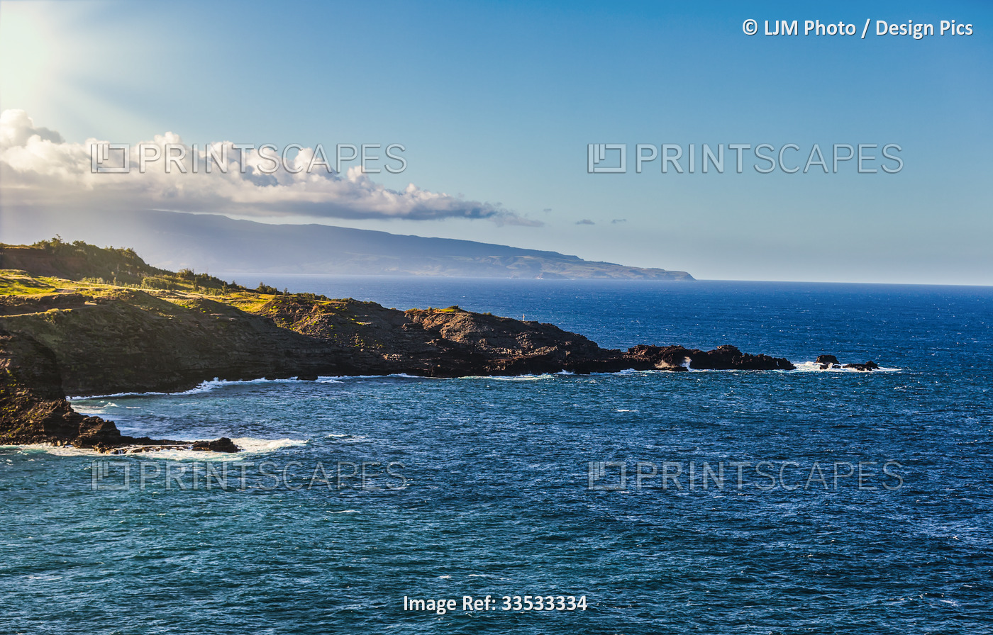 View of the ocean and horizon against a blue sky with the rugged, rocky ...