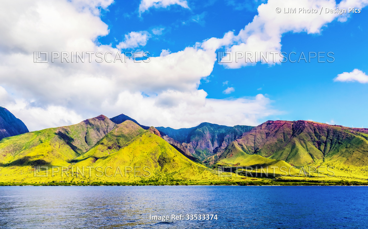 The rugged landscape of the island of Maui under a blue sky with cloud; Maui, ...