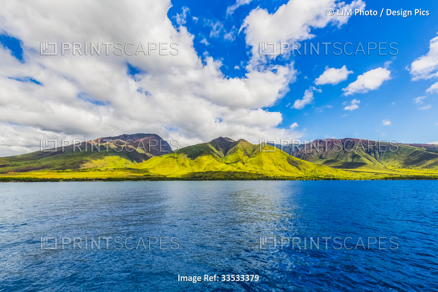 The rugged landscape of the island of Maui under a blue sky with cloud; Maui, ...