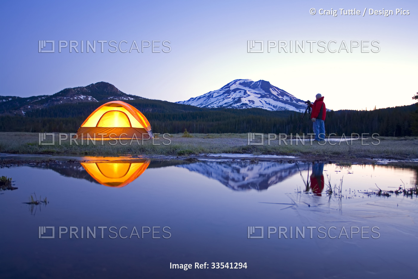 Man with a camera and tripod photographing Oregon beauty at sunrise next to ...