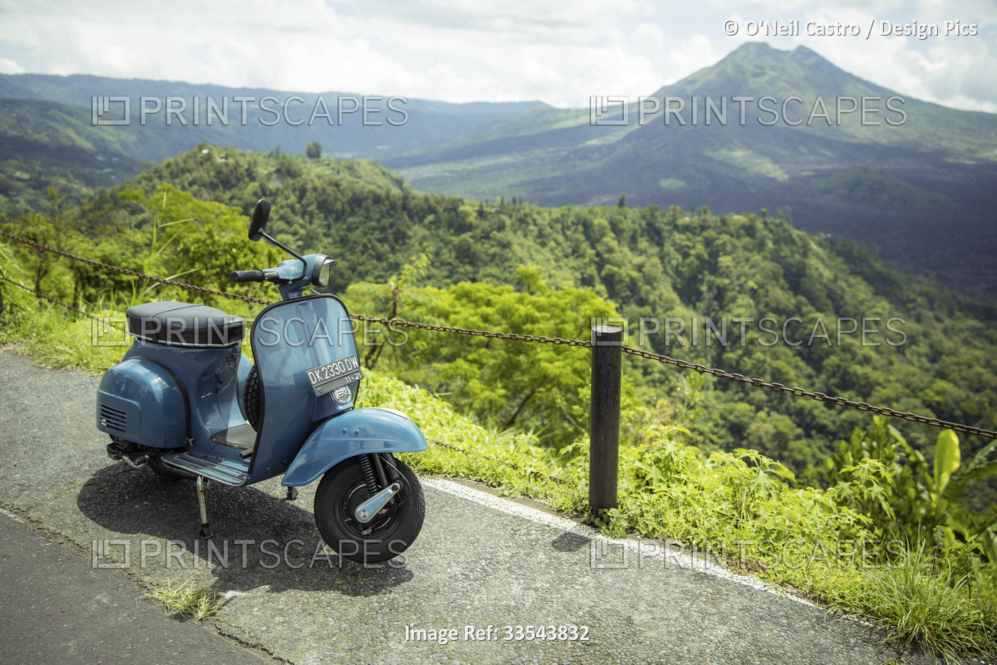 Moped parked along the side of the road at a lookout with views of Mount Batur ...