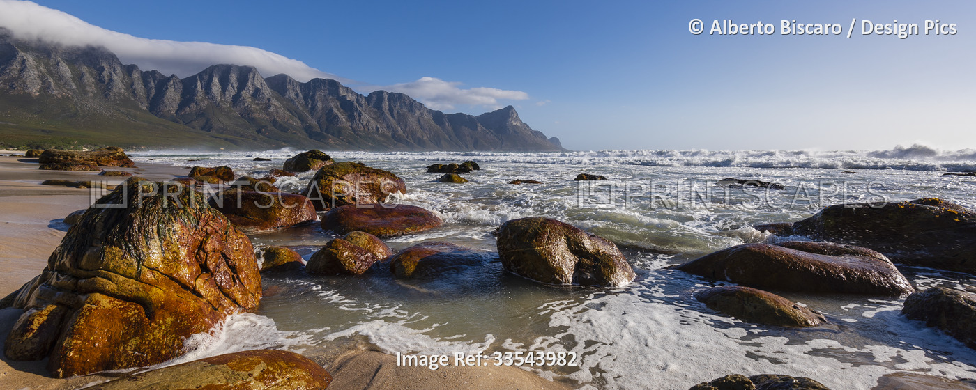 Rocky beach with Atlantic Ocean surf at Kogel Bay along the scenic R44 Route ...