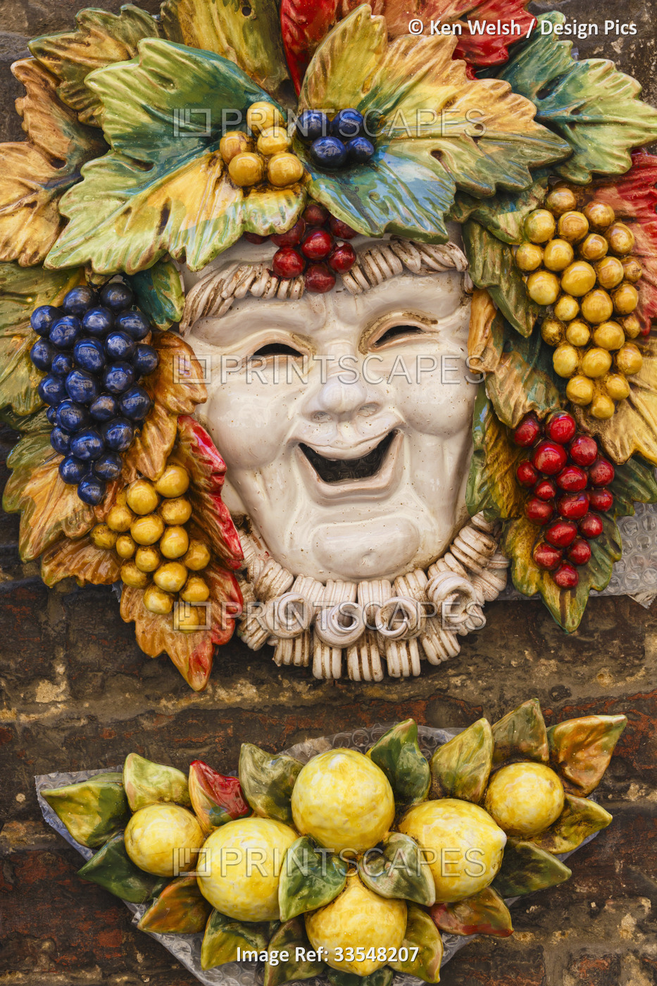 Siena, Siena Province, Tuscany, Italy.  Ceramic mask of a laughing Bacchus.