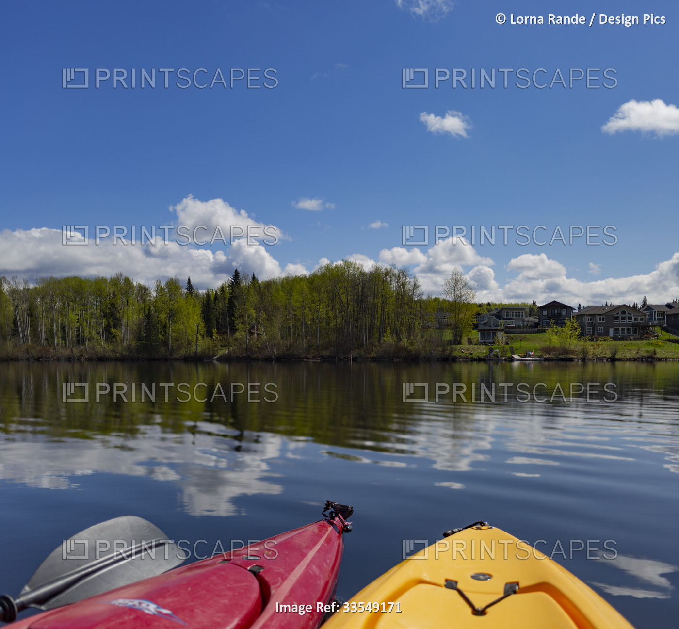 View of lakefront homes along the shore seen from kayaks on the calm waters ...