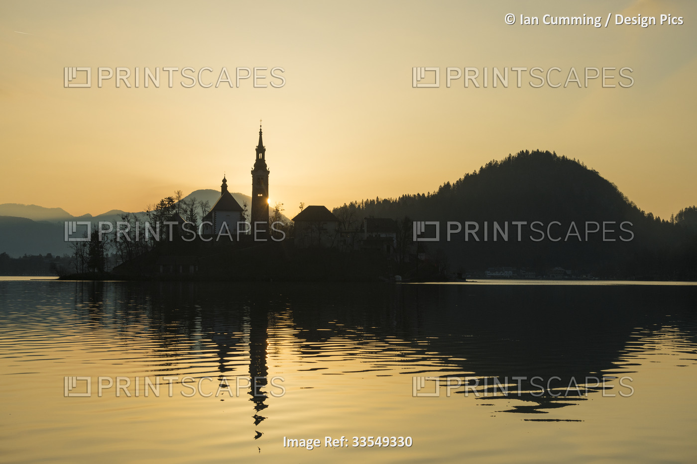 Silhouette of church and other buildings on Lake Bled at dawn; Bled, Slovenia