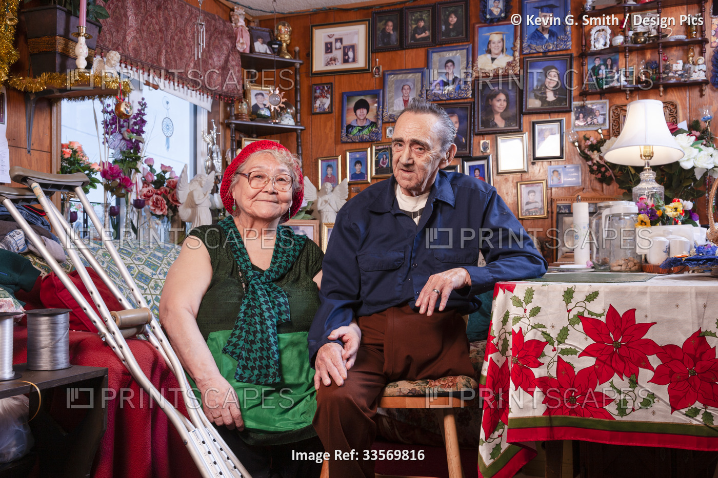 Alaska Native Yupiik Elder couple sitting in their living room holding hands, ...