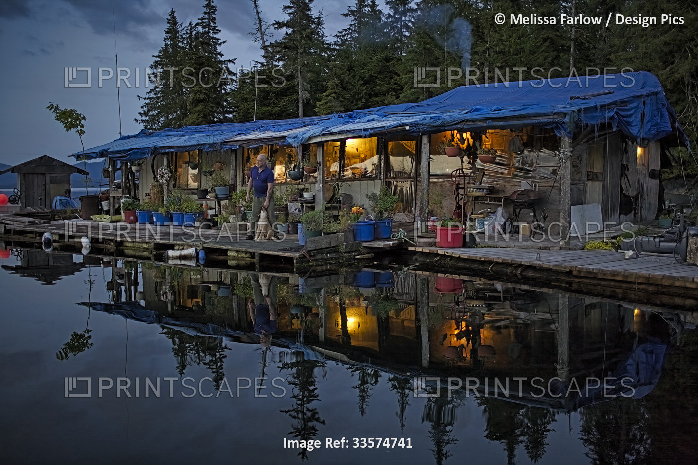 A rustic, float house, characteristic in Southeast Alaska, is reflected in the ...