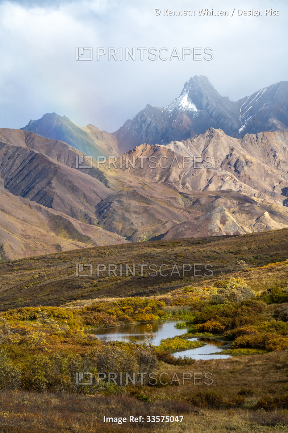 Brilliant rainbow and rugged mountains near Sable Pass in Denali National Park ...