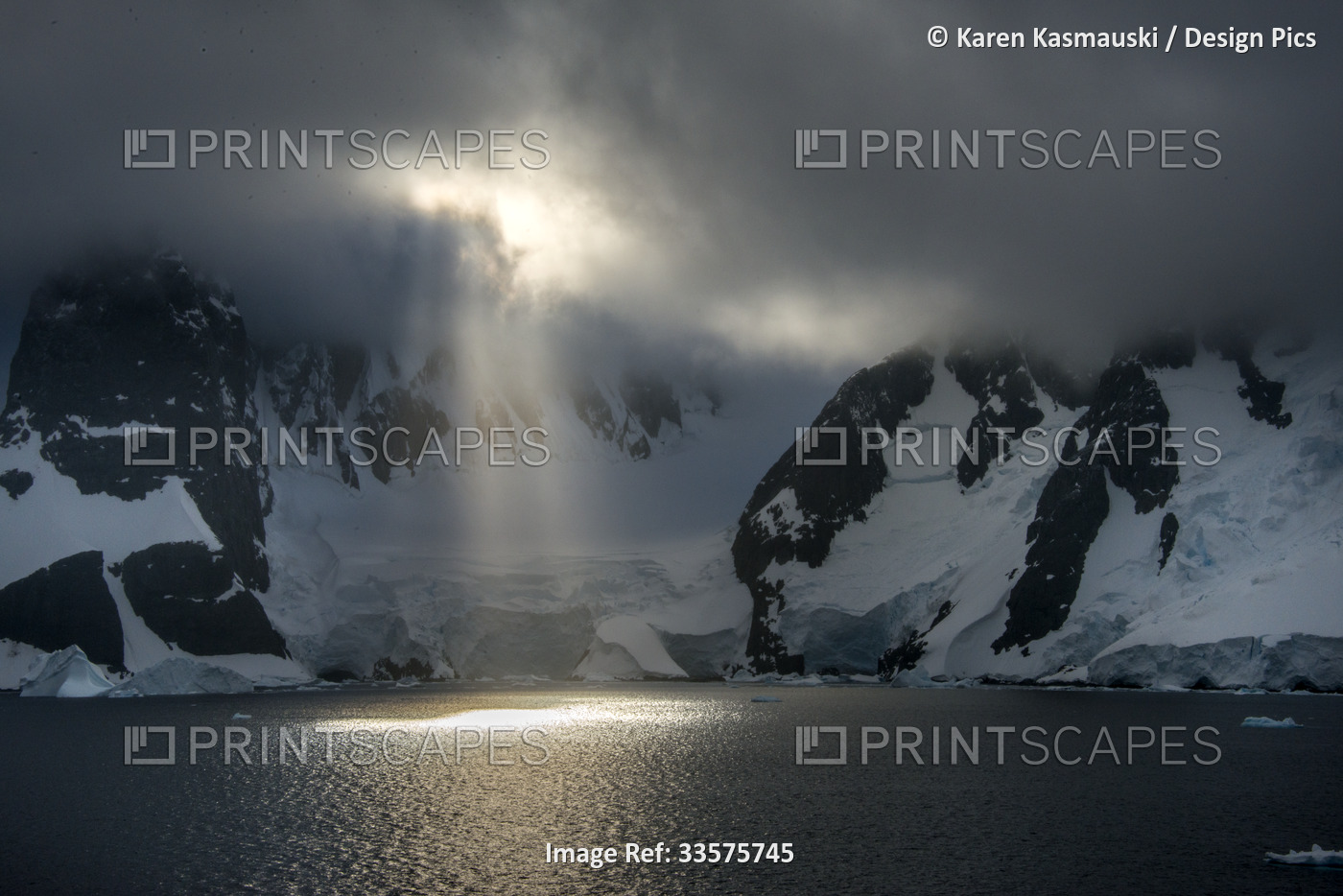 Early morning sun breaking through cloud cover in Antarctica's Lemaire Channel; ...