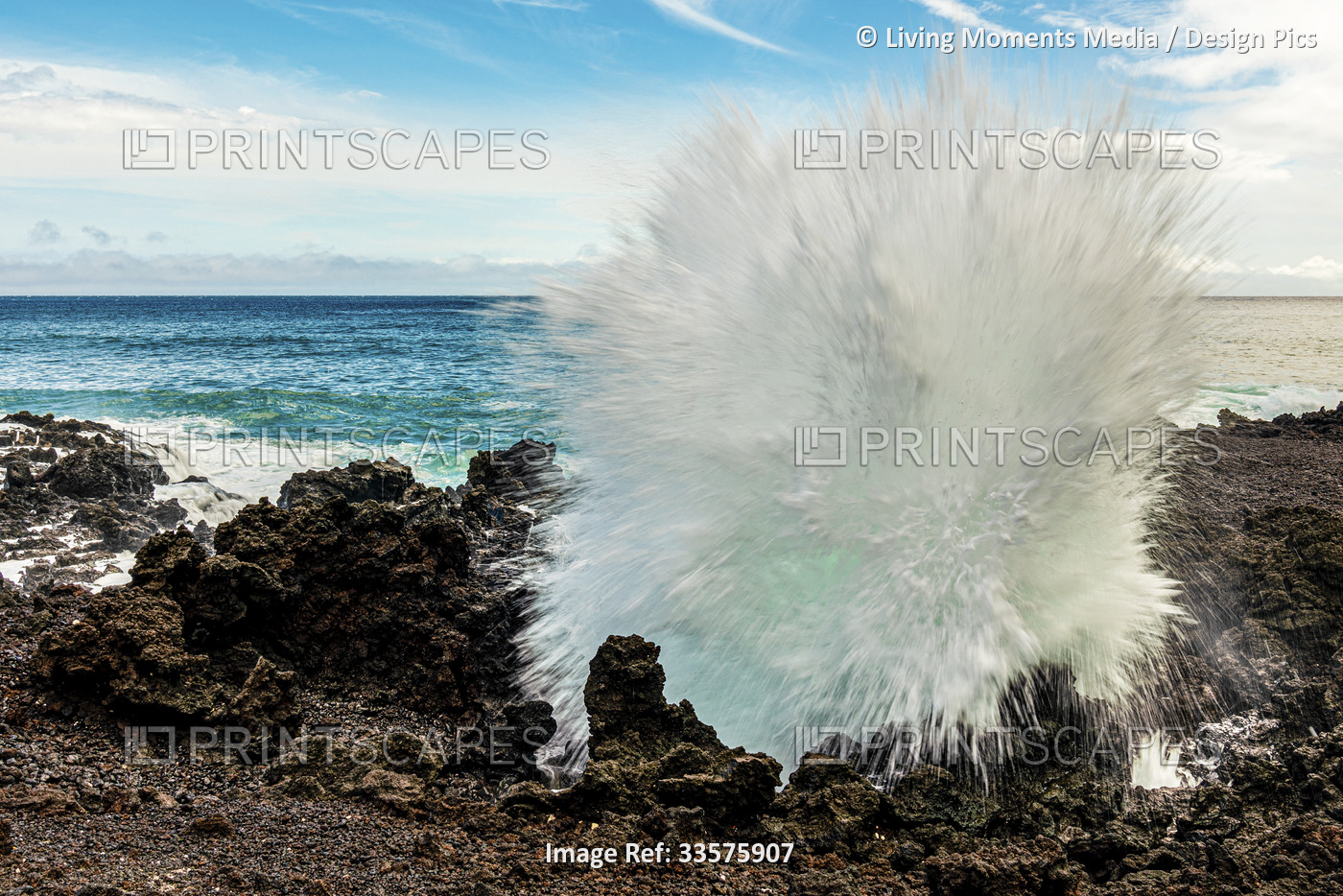Close-up of the splashes of a breaking wave on lava rock on the shore of Maui, ...
