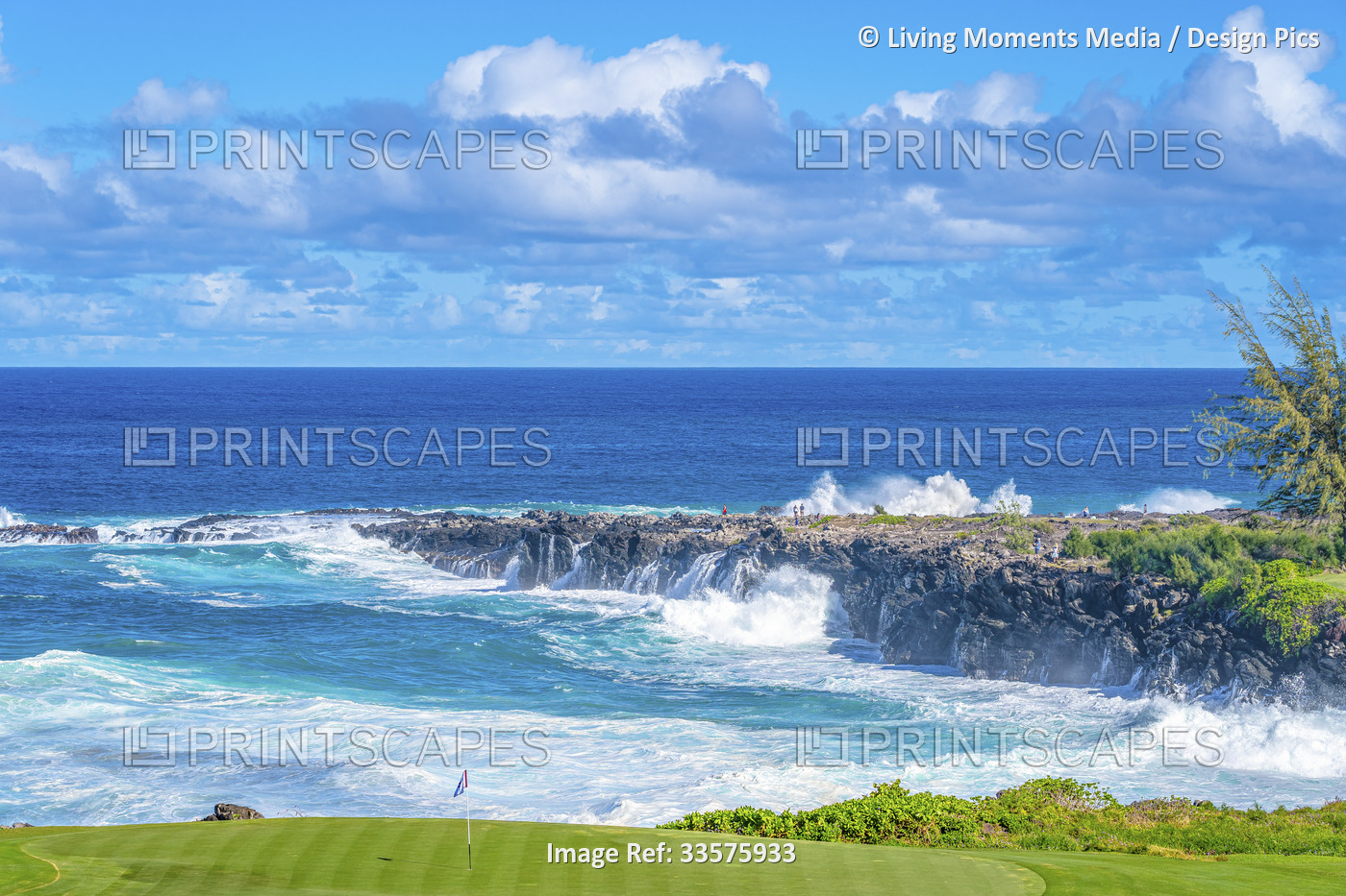 A golf course on the coast of Maui, Hawaii with the surf crashing up on the ...