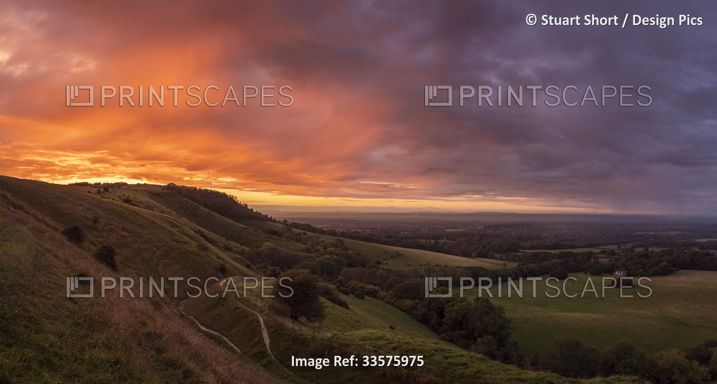The sun sets over England's South Downs National Park, lighting up the rainfall ...