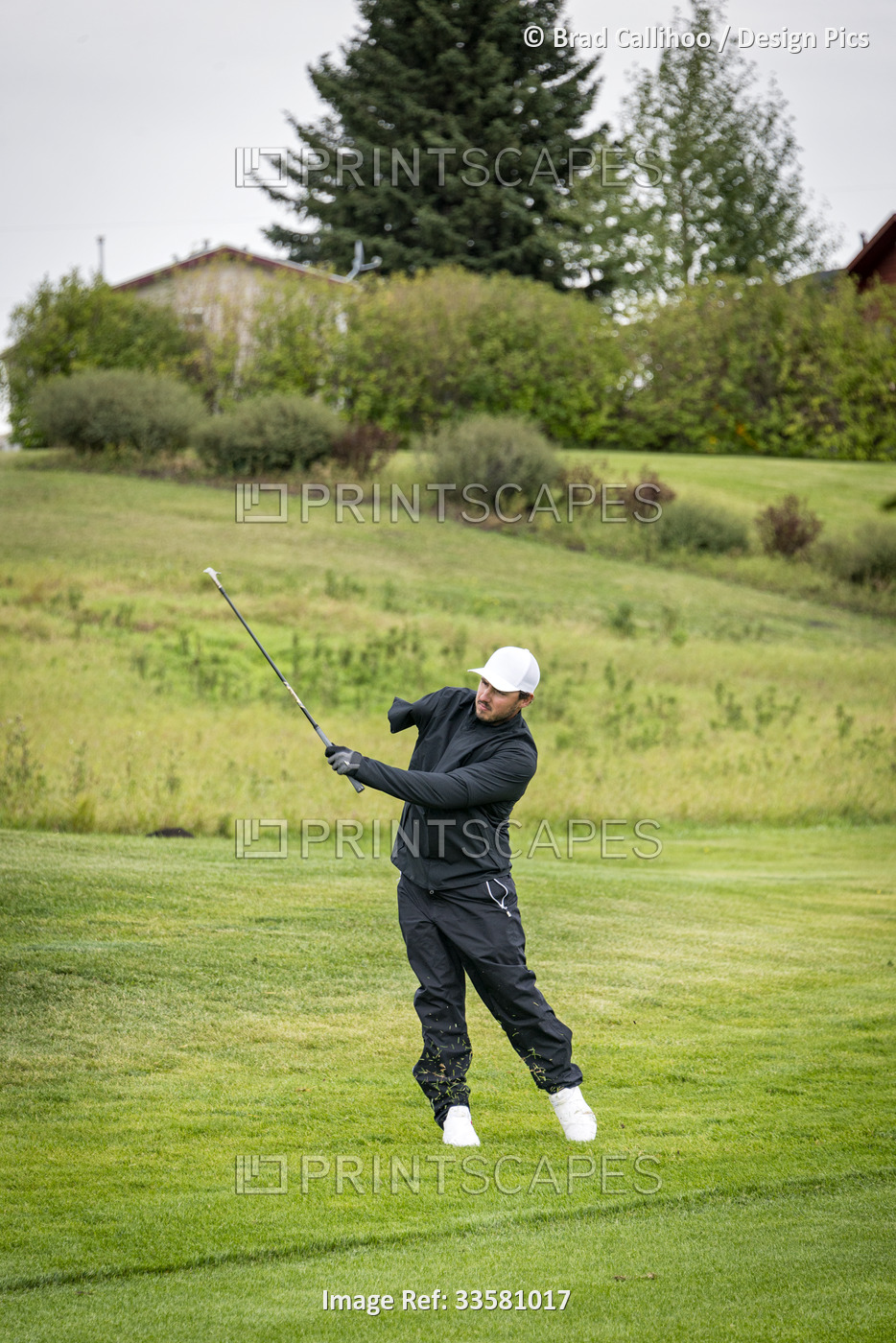 Amputee with one arm taking a swing on the golf course; Okotoks, Alberta, Canada